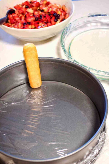 Placing lady fingers in the pan.